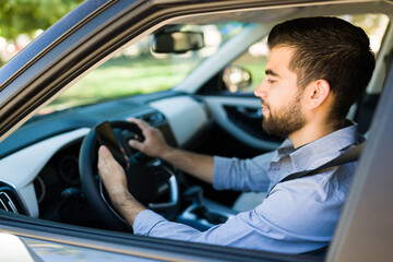 Fototapeta na wymiar Attractive man texting while driving