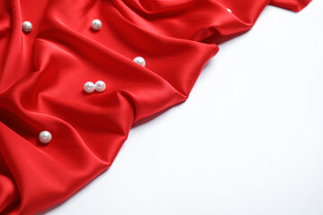 Texture of delicate red silk with pearls on white background