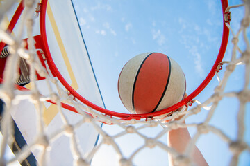 dunking in basket. slam dunk in motion. professional player. sport success. © Olena