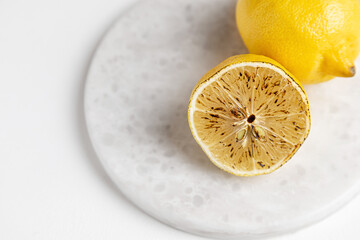 half grilled lemon on a marble board and one lemon in the background
