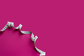 Centimeter tape, fitness and weight loss. Tailor's meter, for sewing, on a blue background. Meter, tape measure, to measure the body, waist in centimeters.