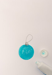 Blue Christmas ornament made of toothpaste on white background. Flat lay creative concept.