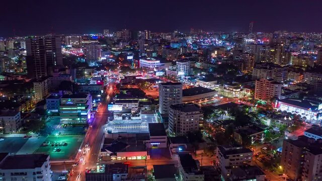 Night timelapse of Santo Domingo town center illuminated. Aerial forward