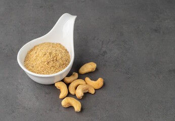 Cashew nut flour in a bowl over stone background. Gluten free flour