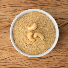 Cashew nut flour in a bowl over wooden table. Gluten free flour