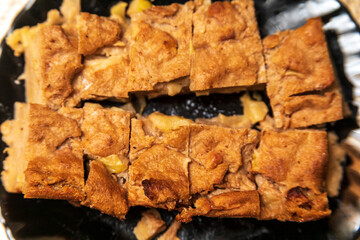 Apple pie on a black plate in the kitchen