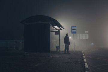 Alone sad man waiting for bus at bus stop