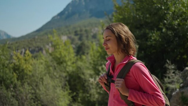 cinematic 4k slow motion attractive woman hiker walking outdoors in mountains with forest on background, happy girl hiking at sunny day, adventure outdoor lifestyle
