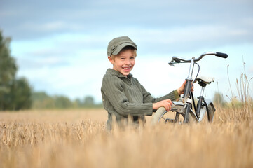 Smiling, little boy with a bicycle, a natural photo.