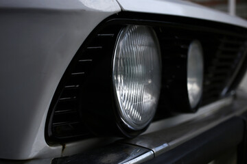 Round headlights of an old retro german car, style of 80th.