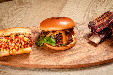 fast food burger hondog and ribs on wooden background