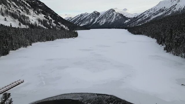 Aerial view of snow mountains and lake. Winter nature