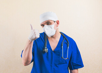 Young doctor portrait with thumb up in blue surgeon suit isolated