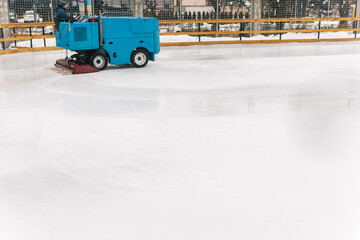 Worker with machine of figure skating field clearing the ice