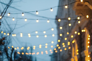 Obraz premium Snow falling in a night city with warm lights