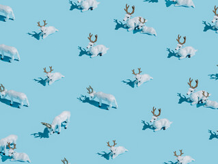 Christmas layout pattern with white reindeer toys isolated on pastel blue background. Creative New Year and holiday season concept. Minimal Xmas texture banner or greeting card. Flat lay, top view.