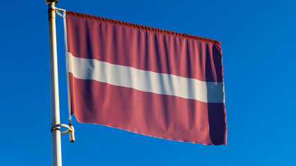 Flag of the Republic of Latvia. Flag of Latvia against the blue sky. Diplomacy concept. International relations.
