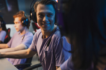 Man wearing headphones rejoicing in victory professional gamer playing online