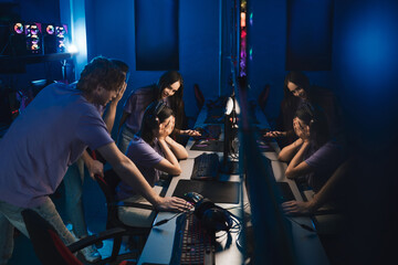 Professional young diverse gamers playing online at the PC in the night room