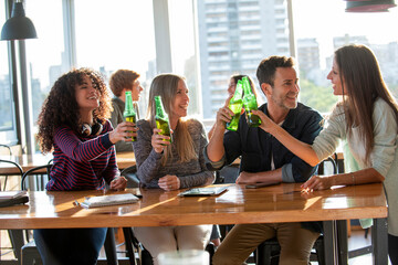 Smiling business people toasting bottles in office
