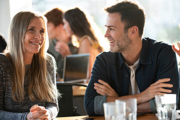 Mature man and mature woman talking in office