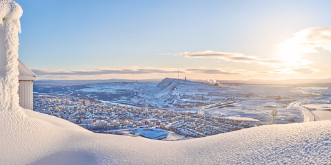 View of Kiruna city and the iron ore mine on the mountain Kiirunavaara seen from the snowy mountain...