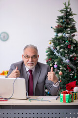 Aged male employee celebrating Christmas at workplace