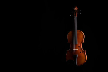 A wooden violin or viola on a black background