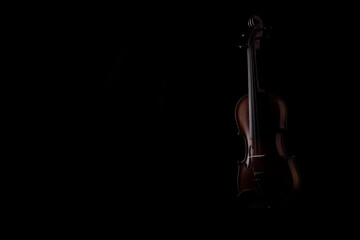 A wooden violin or viola on a black background