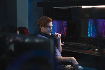 Man wearing headphones sitting at the armchair and relaxing after online streaming