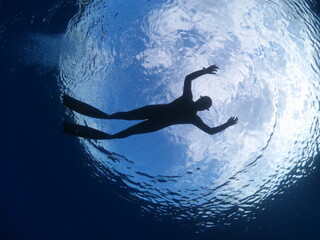 free diver snorkeling on the surface sky clouds underwater lady woman freediver