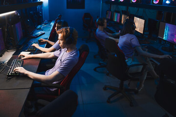 People wearing headphones playing online and being involved at the cyber sport