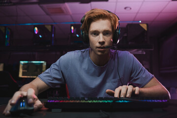 Man wearing headset sitting in front of the computer and being involved at the game © Yakobchuk Olena