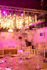 floral arrangement with natural flowers on a table in a party room for an event decorating the table with elegant chandelier and crystal glasses