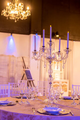 floral arrangement with natural flowers on a table in a party room for an event decorating the table with elegant chandelier and crystal glasses