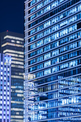 夜の高層ビルの窓の青白い光と窓ガラスに反射するビル © captainT
