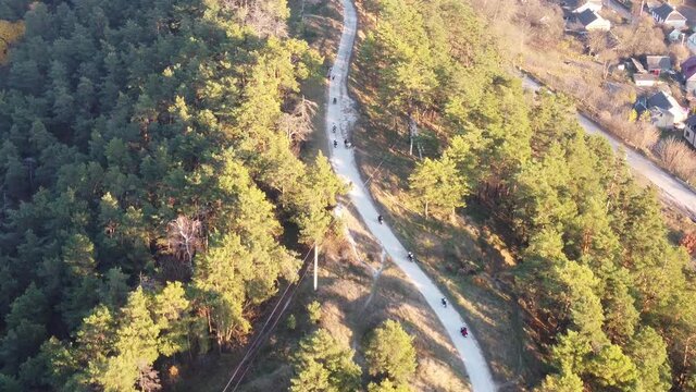 Aerial view of a group of motorcyclists descending down a mountain serpentine road. Bikers on motorcycles