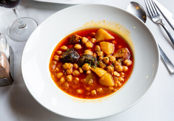 Traditional spanish food garbanzos del pastor, shepherd's chickpeas soup on a white plate