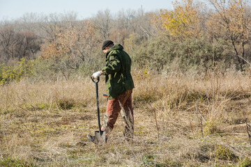 A man with a metal detector. Look for metal in the woods. Precious search engine.