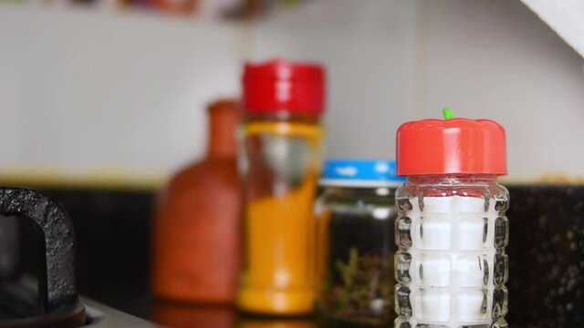 Hand putting a cooking spices pot on a kitchen meson in a kitchen at home 