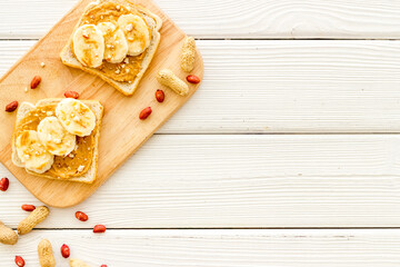 Breakfast with peanut butter sandwiches on white bread, top view