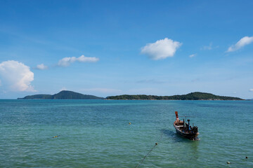 Tropical sea with LongTail boat in the turquoise sea on Paradise island in Phuket Thailand and white clouds in summer season Beautiful Landscape nature view background