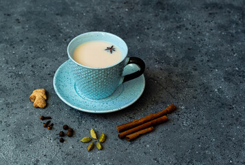 Indian masala chai tea. Masala chai spiced tea with milk and spices on dark rusty background. High...