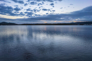 Sunrise waterscape with cloud covered sky