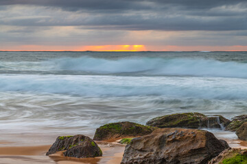 Low cloud covered sunrise seascape with rocks