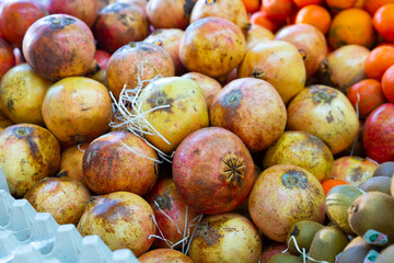 Close up of healthy organic red pomegranates on counter in supermarket