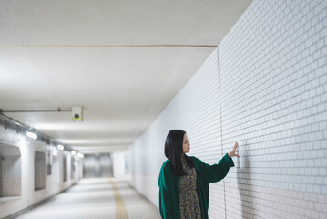 地下道を歩く若い女性