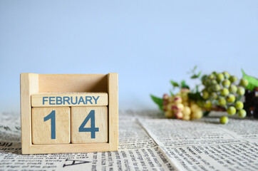 February 14, Calendar cover design with number cube with fruit on newspaper fabric and blue background.	
