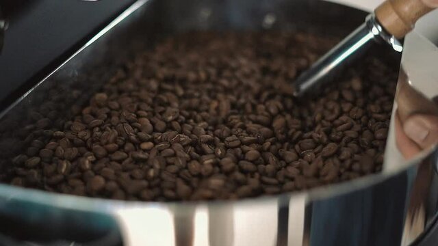 coffee beans mixing. Hand mixing roasted coffee beans. Slow motion of arabica coffee seeds