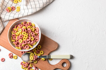 Bowl with crunchy corn flakes rings on white background